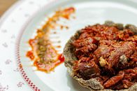 Appetizing delicious dish in tartlet served on plate with sauce