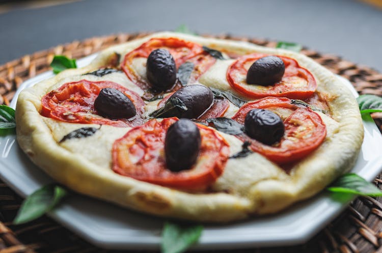 Small Pizza With Olive And Tomato Served In Plate