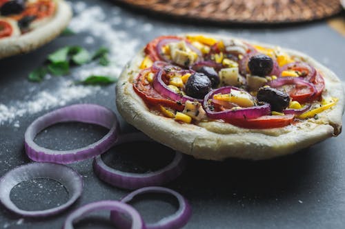 Free Cut pizza with olive and corn on thick dough served on table with flour Stock Photo