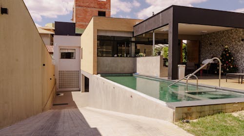 Patio with swimming pool in yard of modern mansion