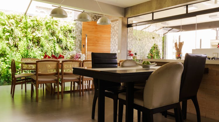 Interior Of Spacious Kitchen With Dining Zone Near Panoramic Window With Garden View