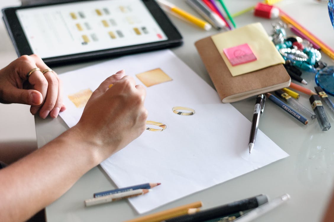 Free Woman drawing sketches of accessories on paper Stock Photo