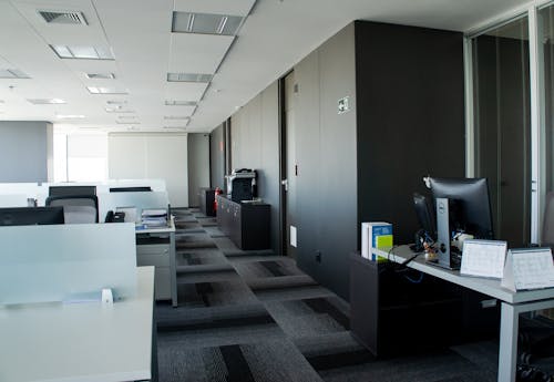 Interior of spacious office room with tables and computers and filing cabinets along wall