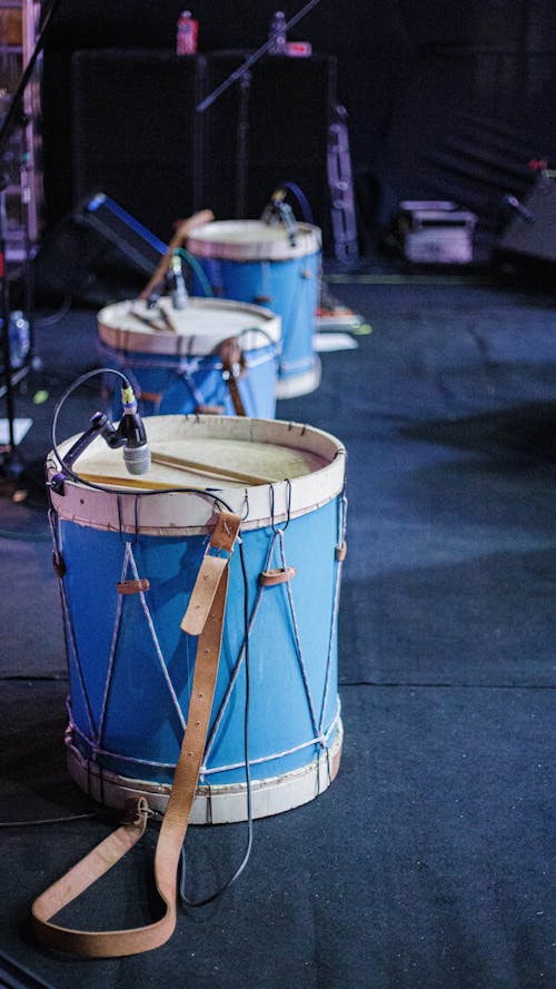 Blue drums with attached microphones placed on stage in music hall before concert