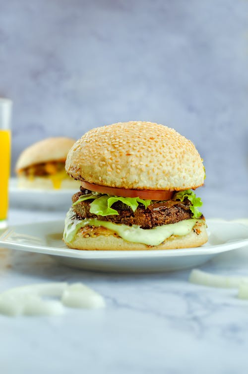Free Hamburger on plate on table in bright room Stock Photo