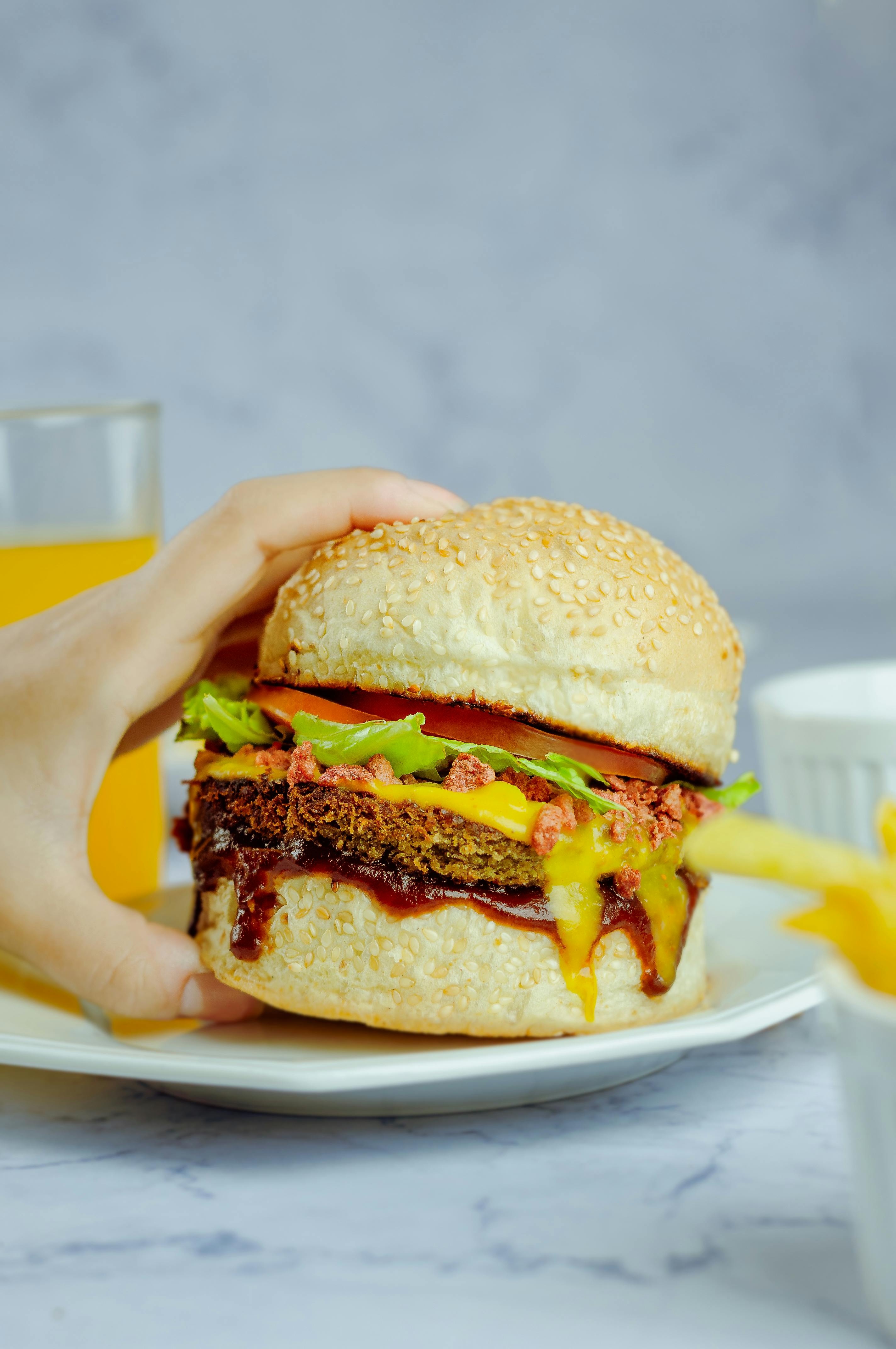 Faceless person eating hamburger in daytime