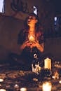 Spooky witch among candles during ritual