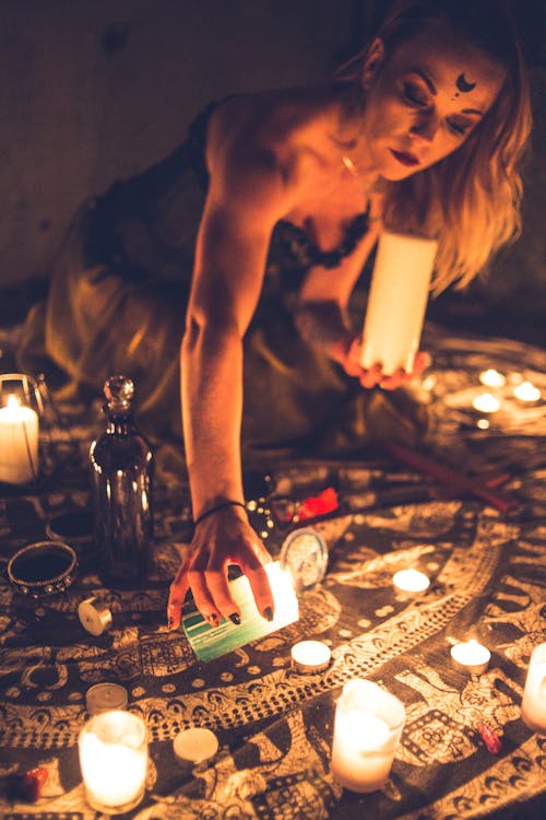 Woman burning candles on carpet for worship