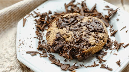 Free High angle of tasty homemade cookie with chocolate pieces on white ceramic plate Stock Photo