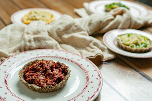 Free High angle of tasty homemade tart with dried tomatoes and pepper in plate on wooden table Stock Photo