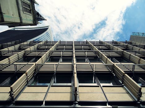 现代城市摩天大楼的低角度视图，带有玻璃窗和抽象建筑设计