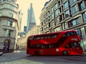 在伦敦繁忙的街道上，充满活力的红色双层巴士行驶在标志性建筑之间