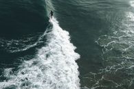Faceless surfer riding waves in ocean
