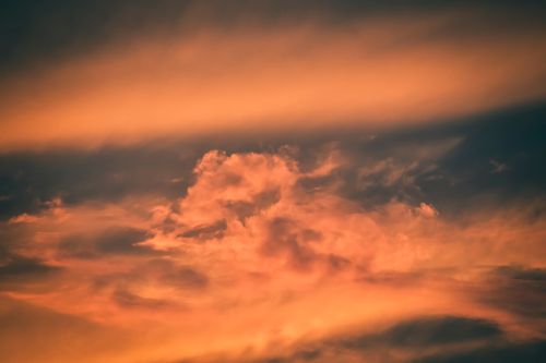 Free Fluffy cumulus orange clouds on peaceful blue sky on sunny evening in summer Stock Photo