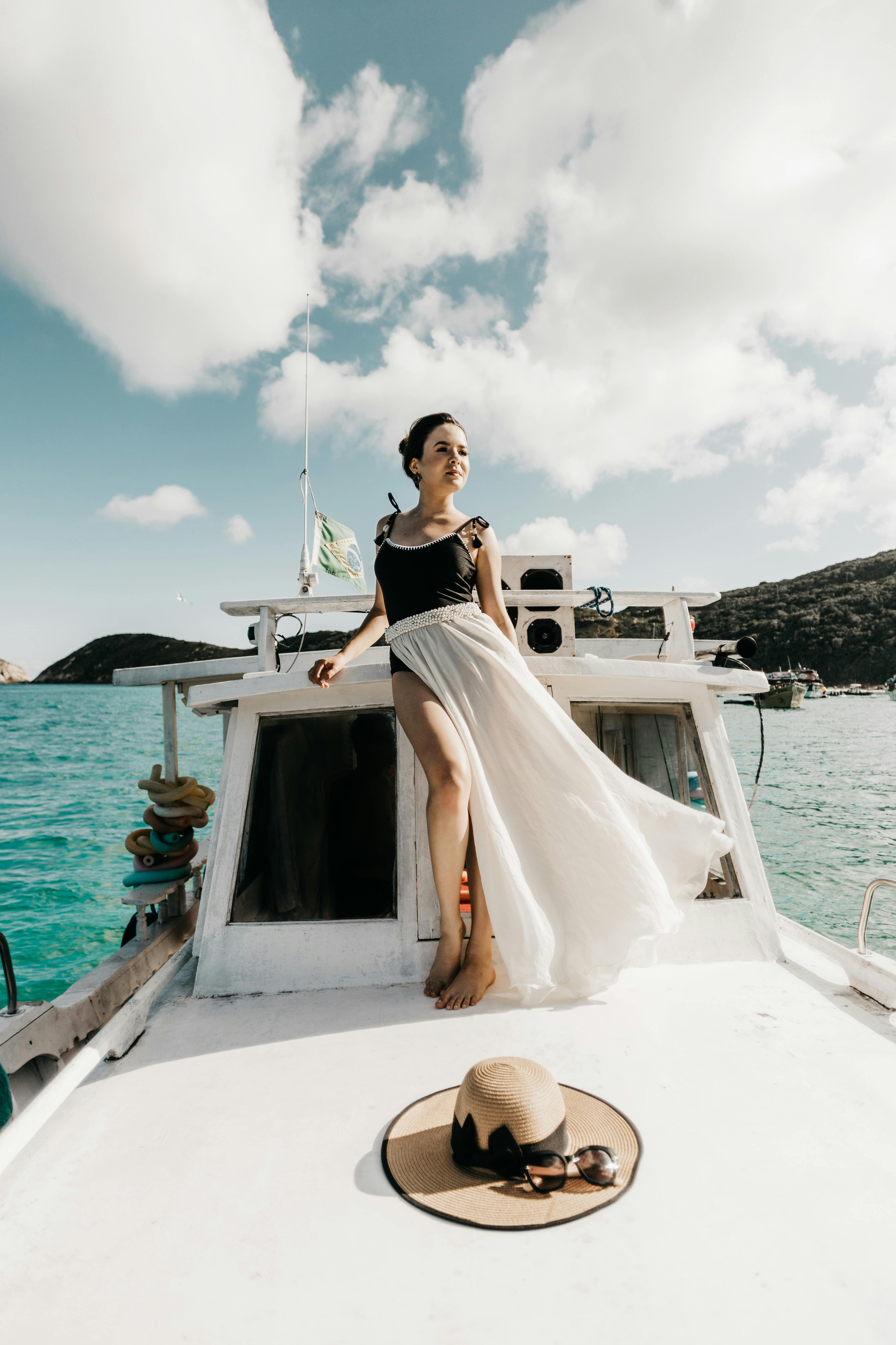 woman in swimwear and white skirt standing on deck