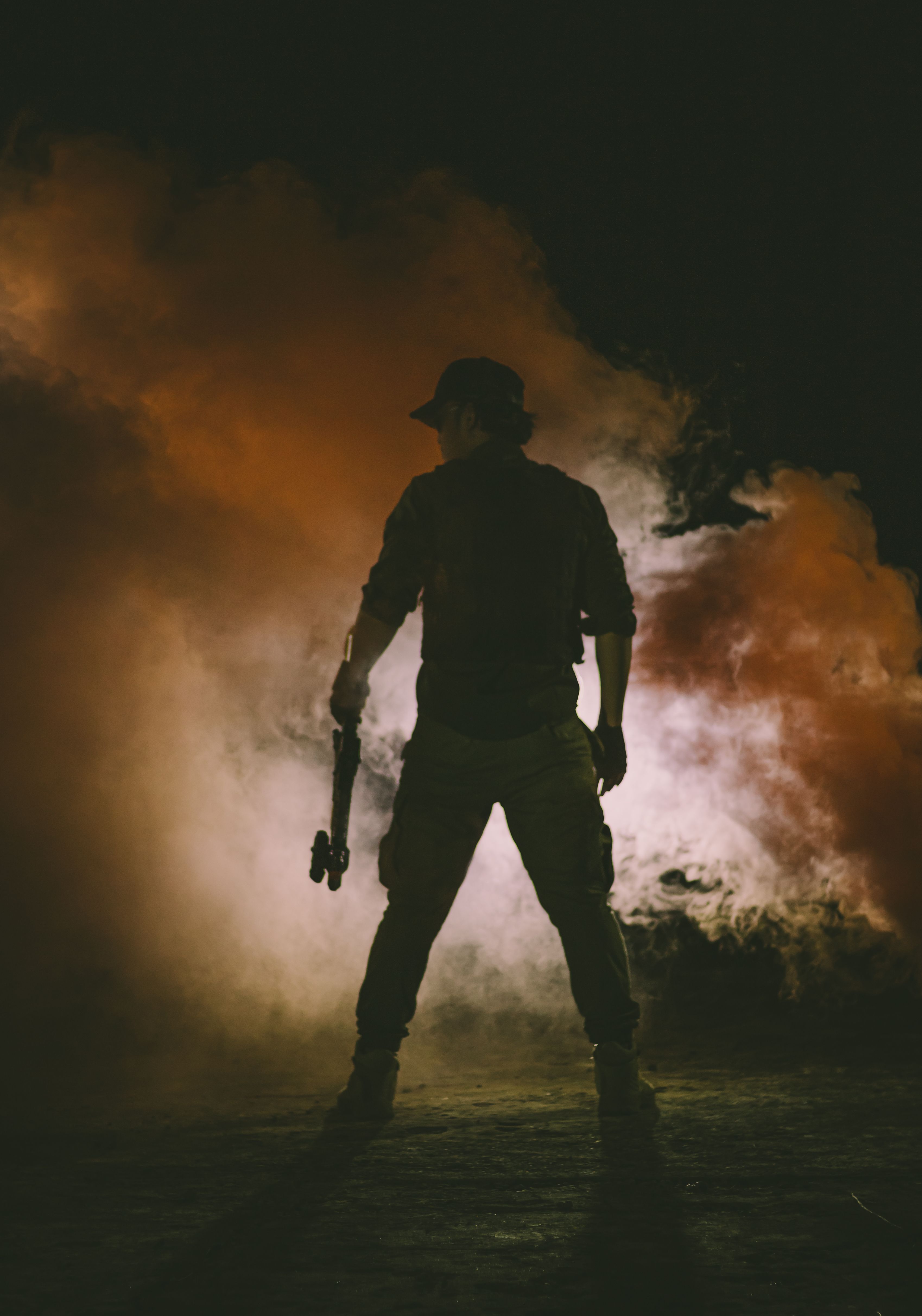 Silhouetted figure standing in drifting orange smoke at night — photo by Nur Andi Ravsanjani Gusma on Pexels