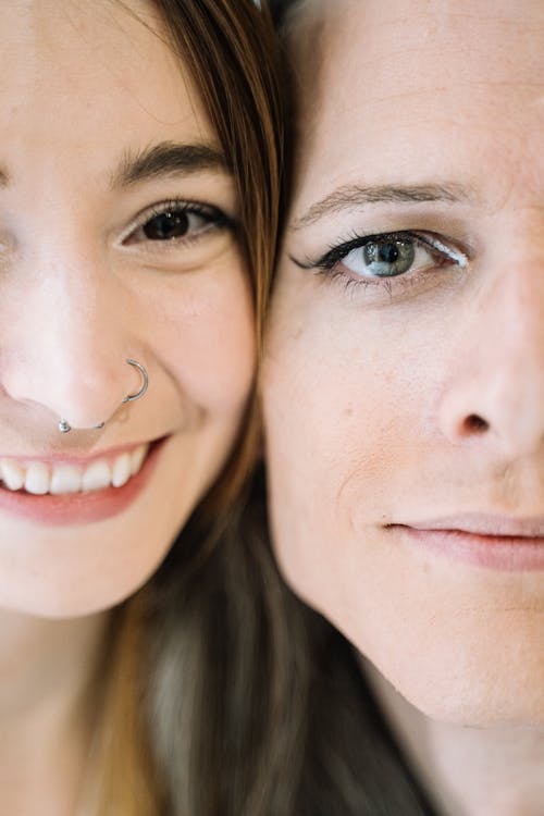 Close-up Photo of Two Women Standing Cheek to Cheek 