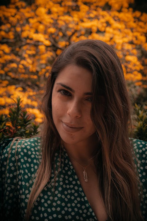 Close-Up Shot of a Pretty Woman in Floral Top Smiling while Looking at Camera