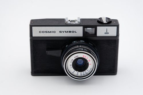 Free Close-up of a retro Cosmic Symbol analog camera on a white background, showcasing vintage design. Stock Photo