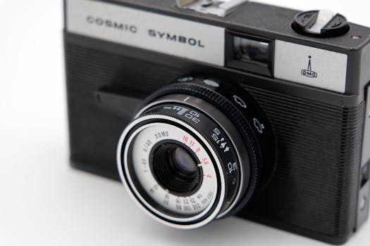Close-up of a vintage retro camera with detailed lens on white surface, classic design.