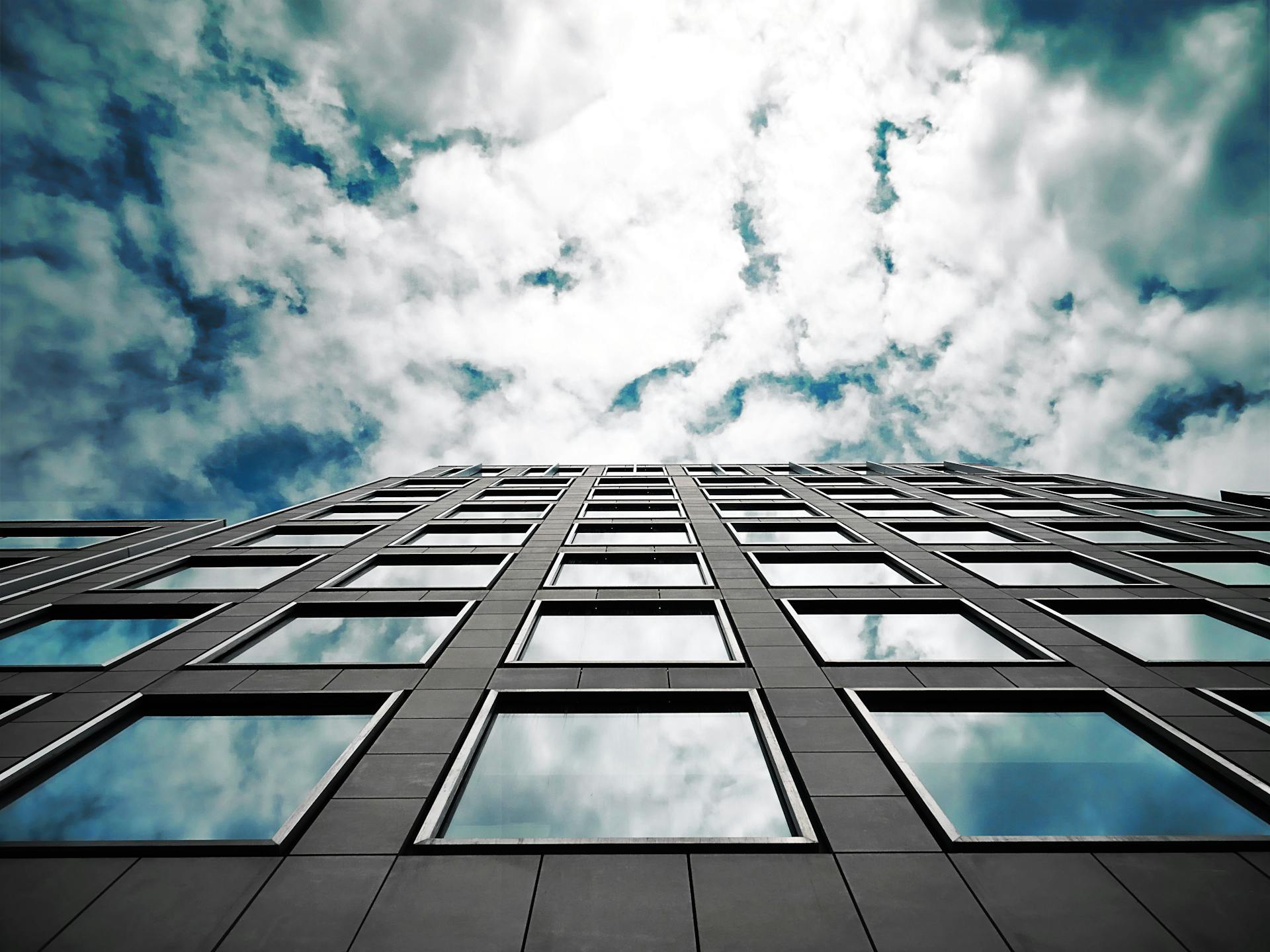 Brown High-rise Building Under Sky Full of White Clouds