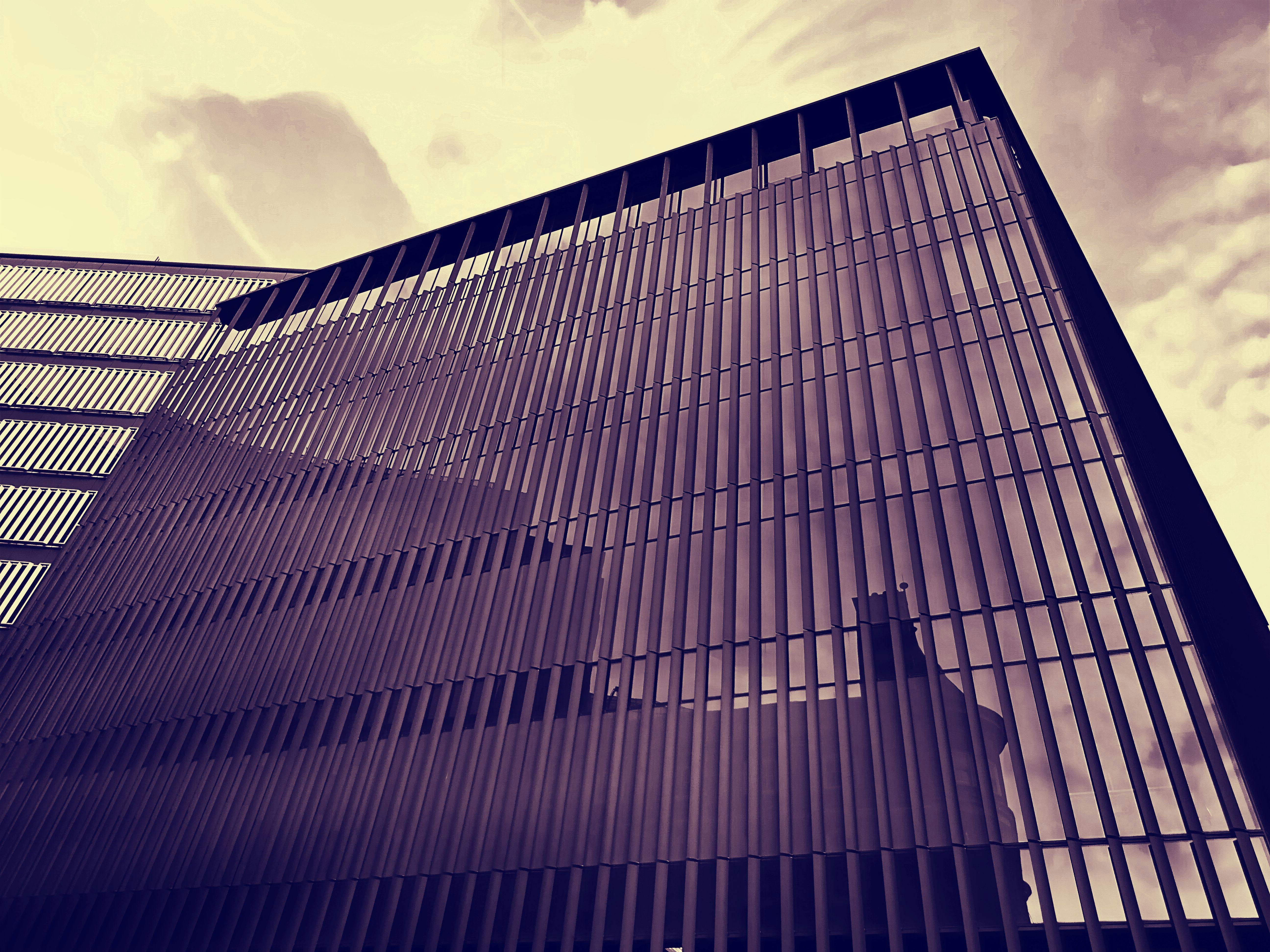 低角度视角下的现代摩天大楼，拥有反光玻璃立面和动态建筑线条