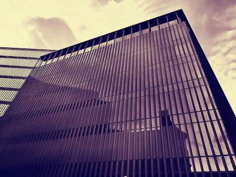 低角度视角下的现代摩天大楼，拥有反光玻璃立面和动态建筑线条