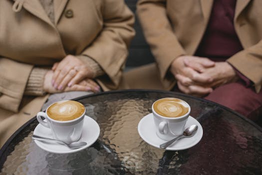 Intimate café scene featuring two lattes beautifully presented on a glass table.