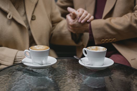 Cozy café setting with a couple holding hands over coffee cups, perfect for romance and love themes.