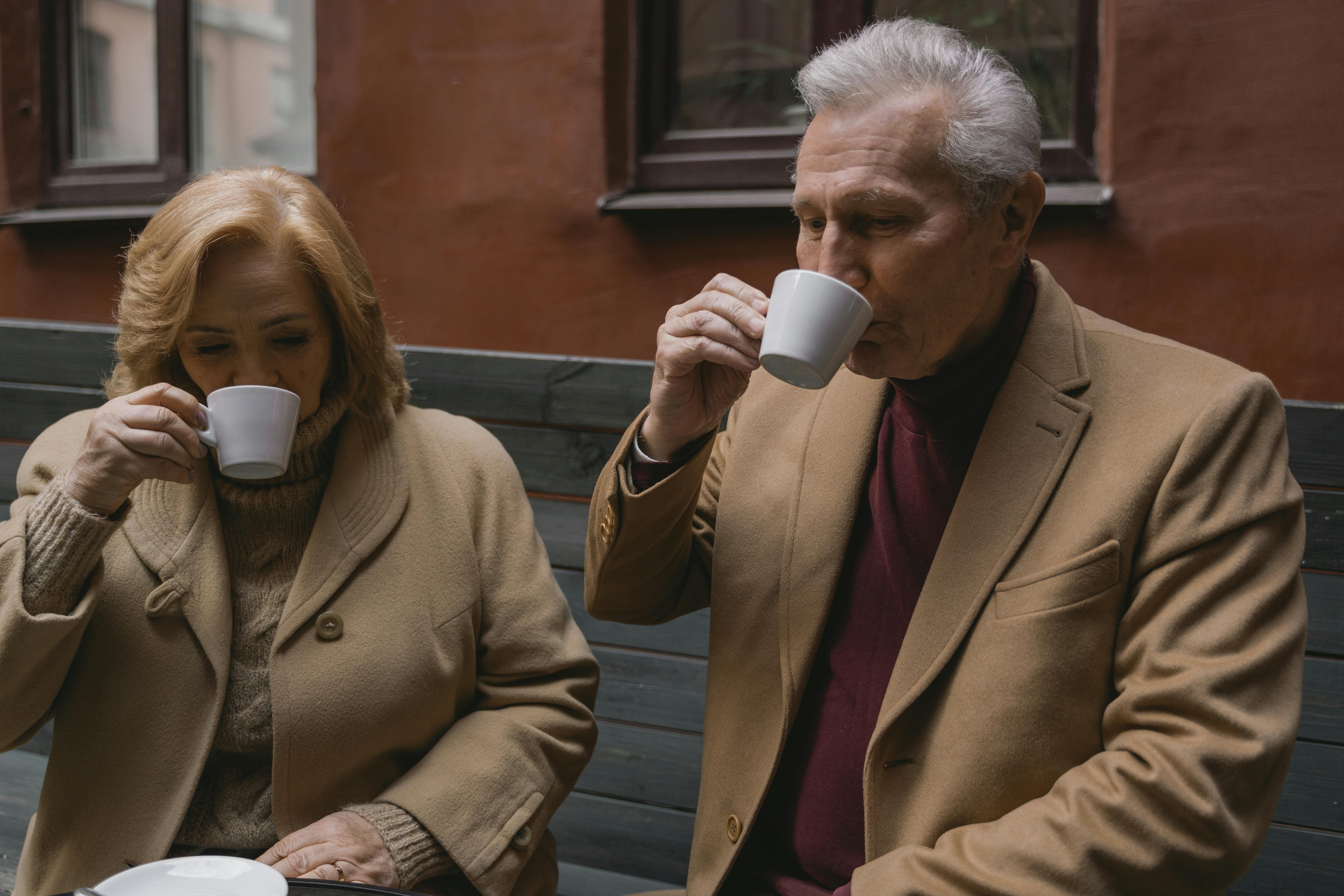Senior couple enjoys warm coffee together, showcasing timeless companionship.