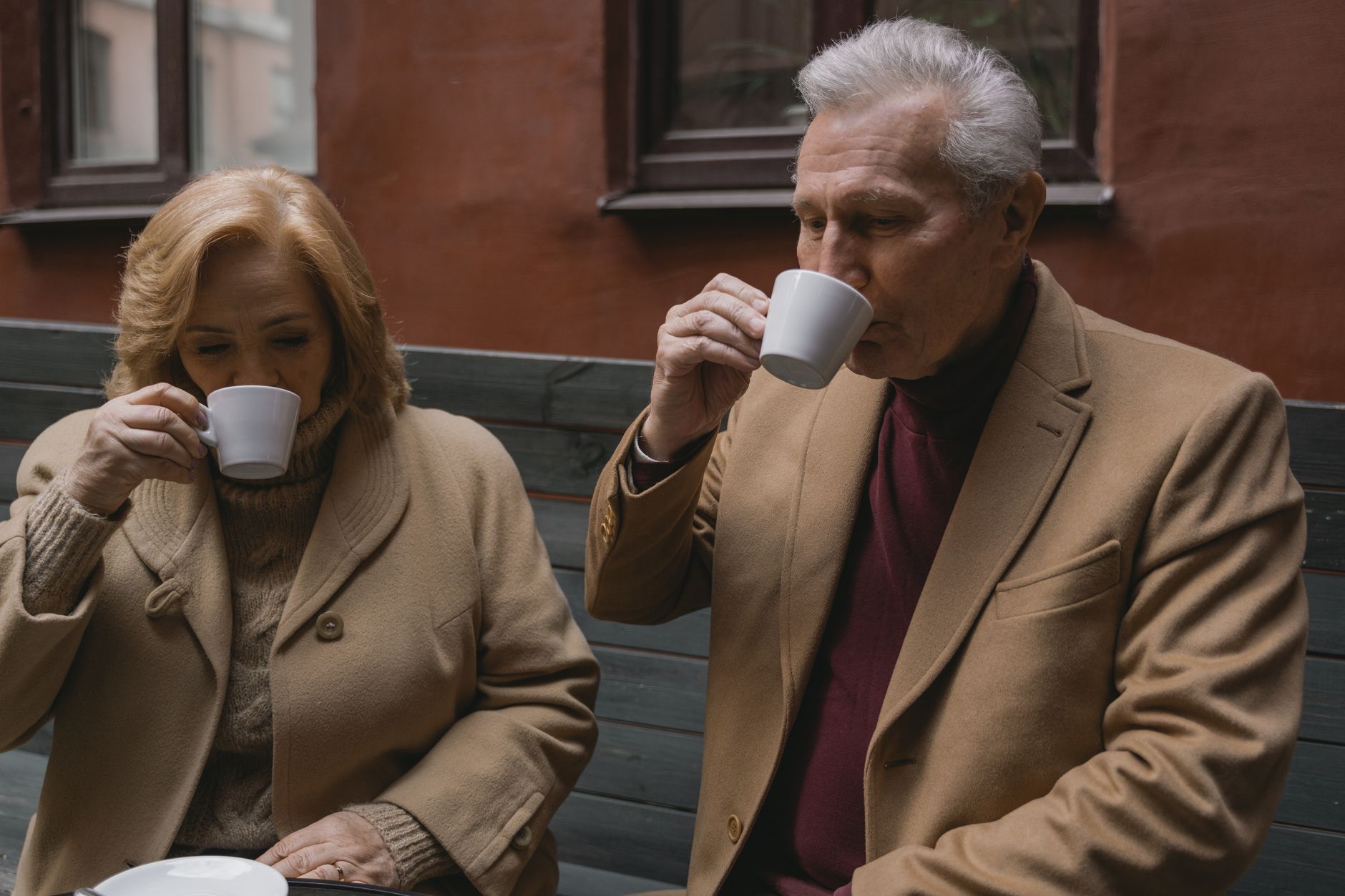 Senior couple enjoys warm coffee together, showcasing timeless companionship.