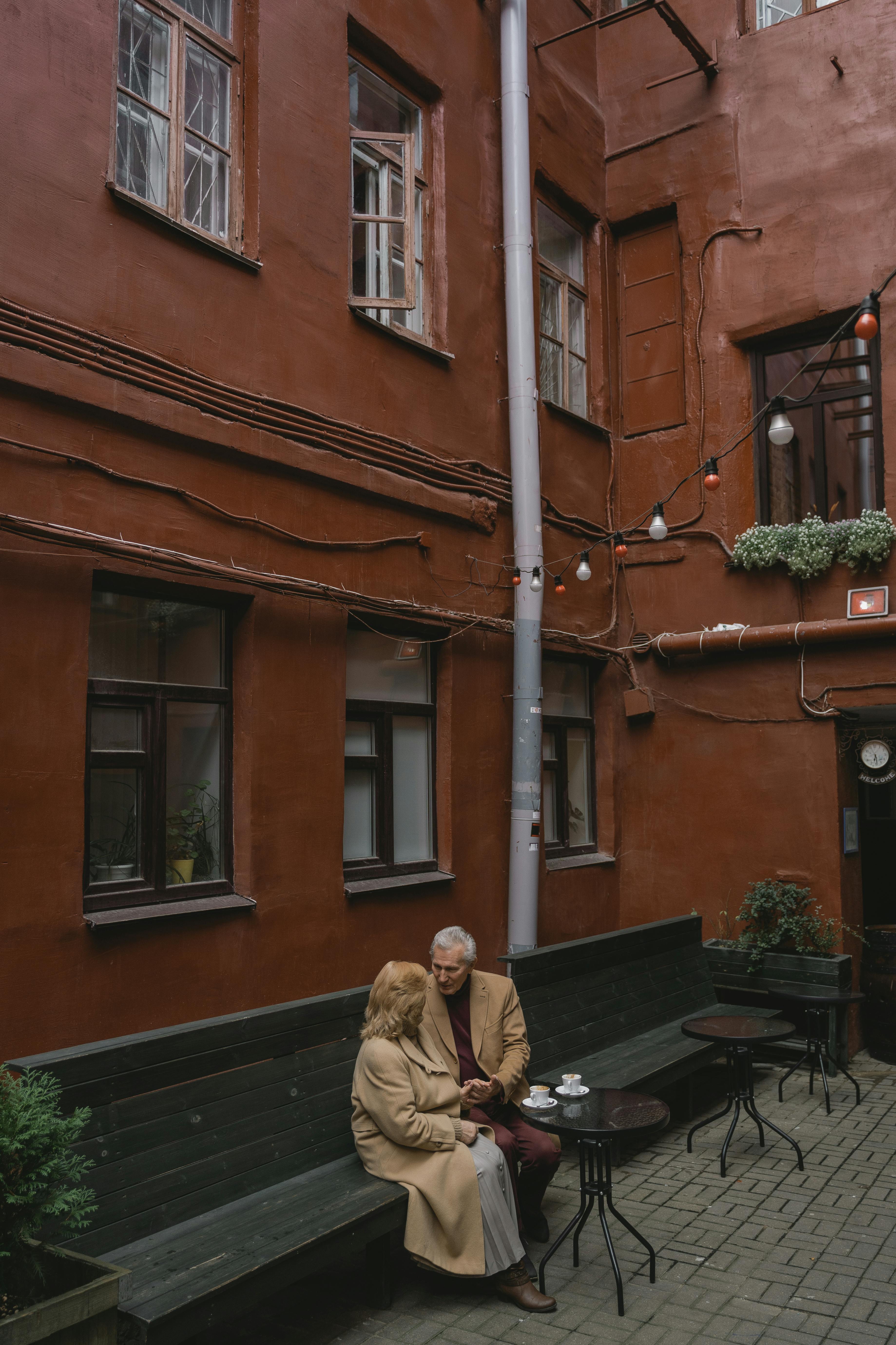 couple sitting on a bench beside a building