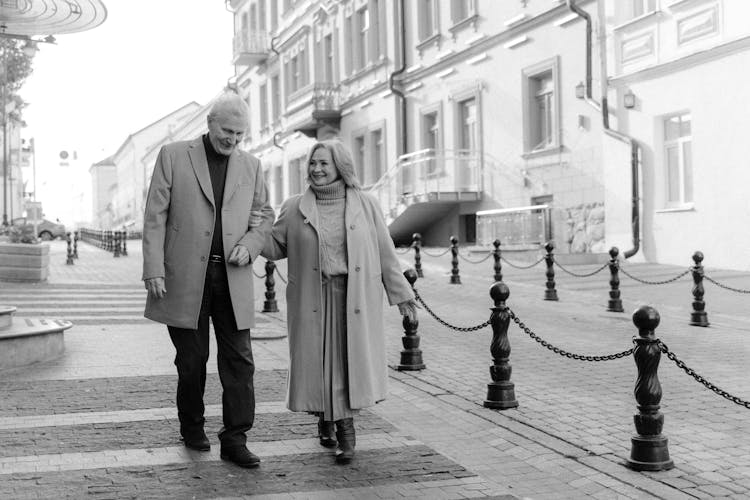 Elderly Couple Walking In The Street Together