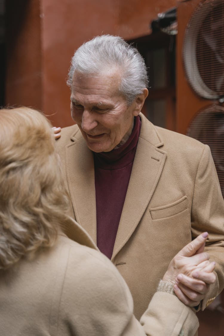 An Elderly Man Dancing With A Woman