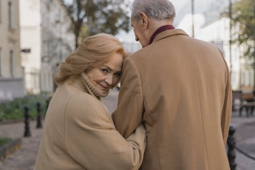 Tender moment of senior couple embracing outdoors in fall, exuding warmth and love.
