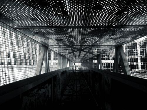 Free Black and white photo of a modern steel tunnel with geometric patterns, creating a futuristic urban feel. Stock Photo
