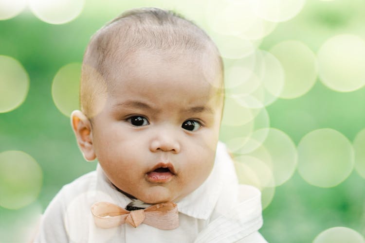 A Toddler In White Shirt With A Bowtie