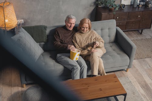 Man and Woman Sitting on Couch with a Bucket of Popcorn
