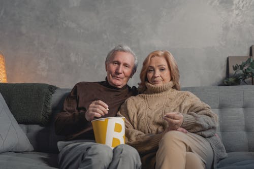 Man and Woman Sitting on Couch and Eating Popcorn