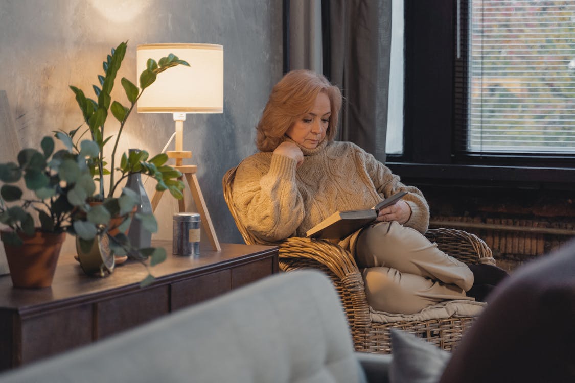 Woman in Brown Sweater Reading Book