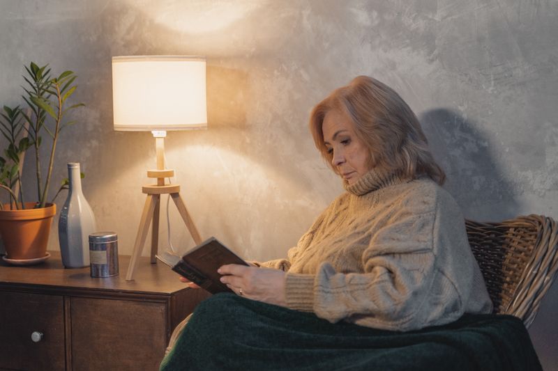 Senior reading in armchair with magnifying glass