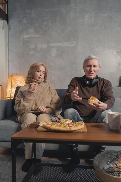 Elderly Couple Eating Pizza