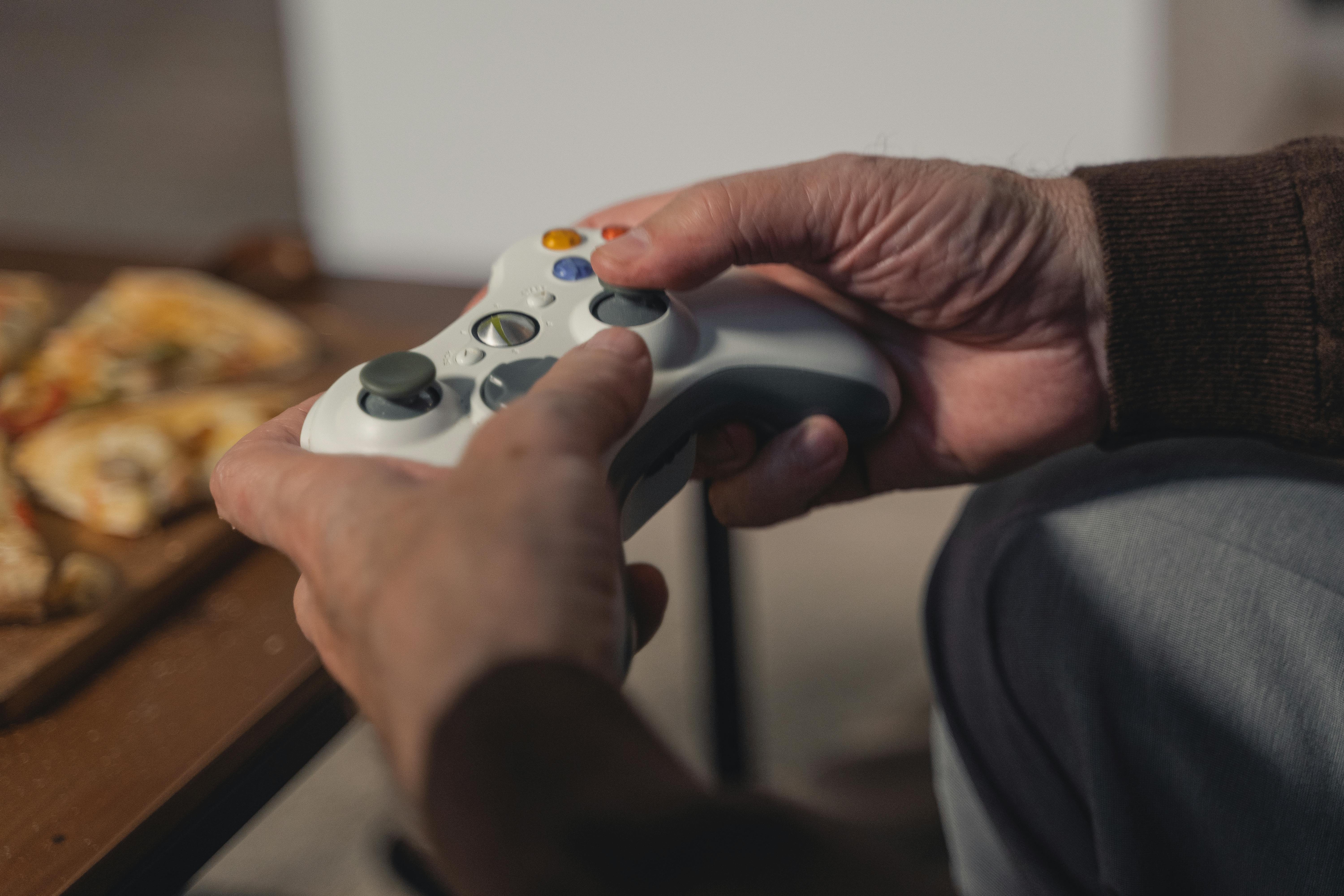 person holding white xbox one controller