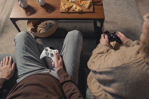 Free Person in Gray Pants and Brown Pants Sitting on Brown Couch Stock Photo