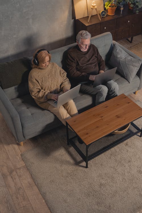 Free Man and Woman Sitting on Gray Couch Stock Photo