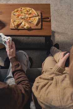 Elderly couple bonding over pizza and video games in a cozy home setting.