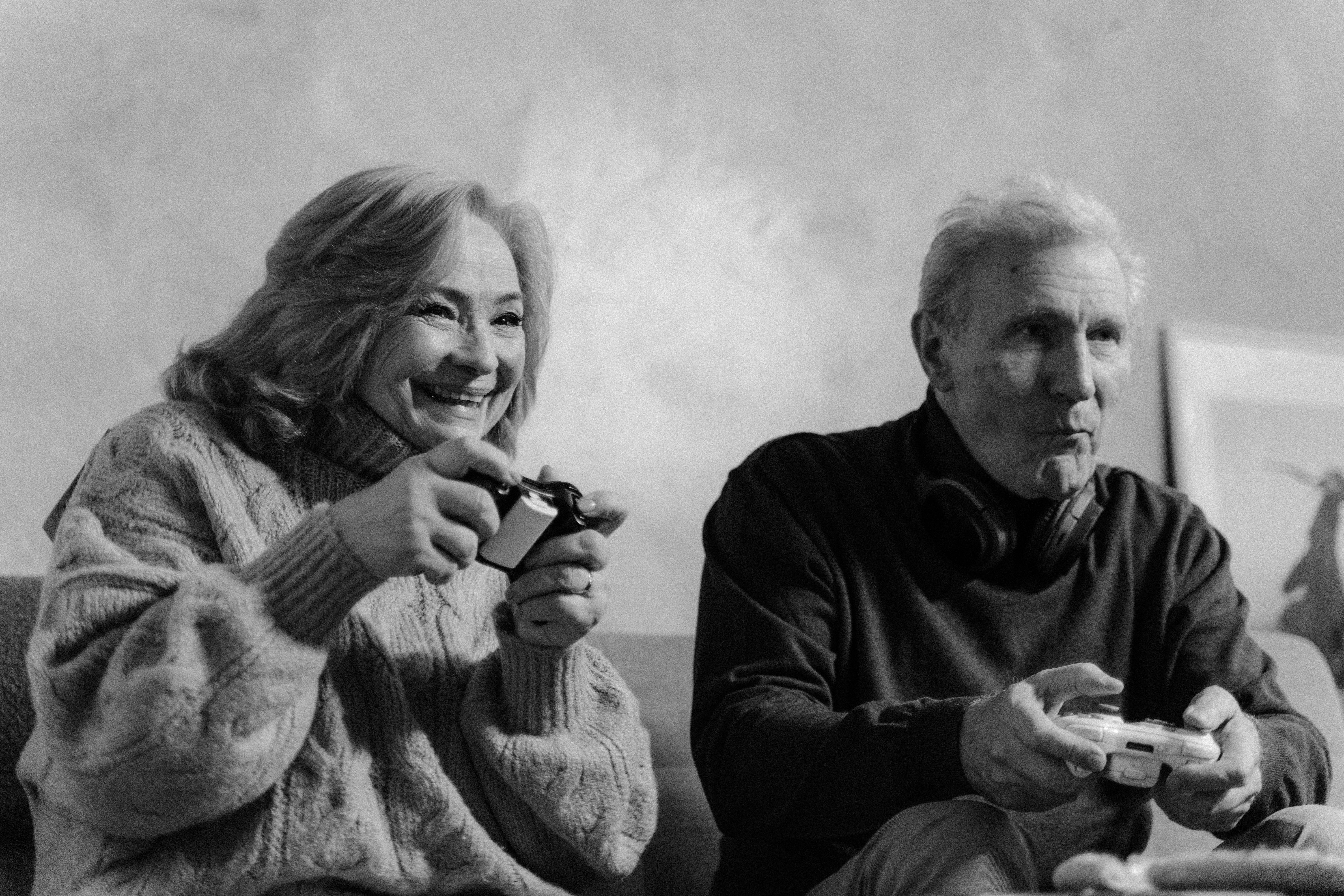 man in black long sleeve shirt holding a woman in white knit sweater