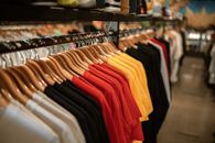 服装店的架子上，衬衫整齐地挂着