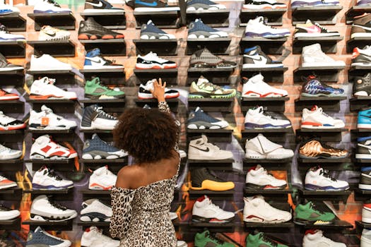 Stylish woman browsing sneakers in a trendy shoe store with a large selection on display.