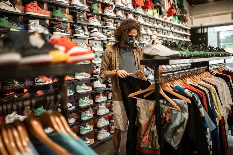 A Man Shopping For Clothes At A Sneaker Shop